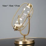 Dekorativ klocka i glas och guldmetall, inspirerad av en vetenskaplig struktur, idealisk för kontors- eller studentdekoration, mått 16 cm x 15 cm x 31 cm.