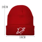Röd ullmössa med design av en planet och stjärnor, perfekt för en vetenskaplig och trendig look.