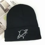 Svart mössa med planet- och stjärnmönster, idealisk för astronomi- och vetenskapsentusiaster, perfekt för vintern eller som trendigt tillbehör.