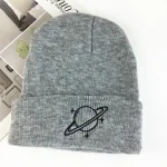 Grå ullmössa med logotyp av en planet omgiven av ringar, perfekt för vintern eller som vetenskapligt modeaccessoar.