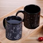 Två svarta muggar med mönster av stjärnor, konstellationer och stjärntecken, perfekta för astronomientusiaster och vetenskaplig inredning.