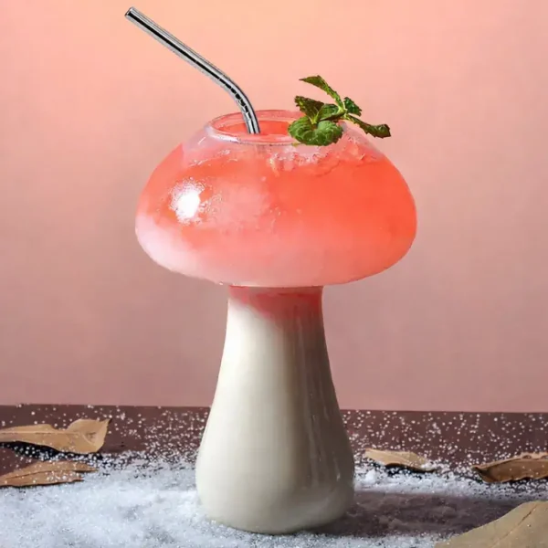 Svampformad glas med en rosa cocktail och en mynta kvist, dekorativ och originell.