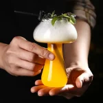 Vetenskaplig cocktailglas med skum, grön garnering och laboratoriedekoration, perfekt för en originell dekoration eller ett vetenskapligt temaevenemang.