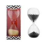 Dekorativt timglas i svart och vitt glas, symbol för tid, perfekt för inredning eller som samlarobjekt.