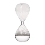 Transparent glas timglas med fin vit sand, symbol för tidens gång och tålamod, perfekt för vetenskaplig eller pedagogisk dekoration.