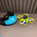 Mini-drönare med fyra färgglada propellrar och skyddshjälm, idealisk för att lära sig flyga säkert. Perfekt för teknik- och gadgetentusiaster.