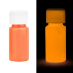 Flaska med fluorescerande orange färg synlig i normalt ljus och luminescent i mörkret, perfekt för dekoration eller ljusa konstprojekt.