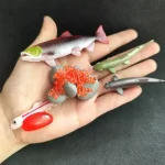 Samling av färgglada plastfigurer av fiskar och marina varelser, perfekta för vetenskaplig eller utbildningsdekoration.
