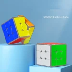 Två ljuskuber, en klassisk Rubik-kub med vita och gröna sidor, och en färgglad ljuskub med blå, gula, orange och röda sidor, placerade på blå plattformar.