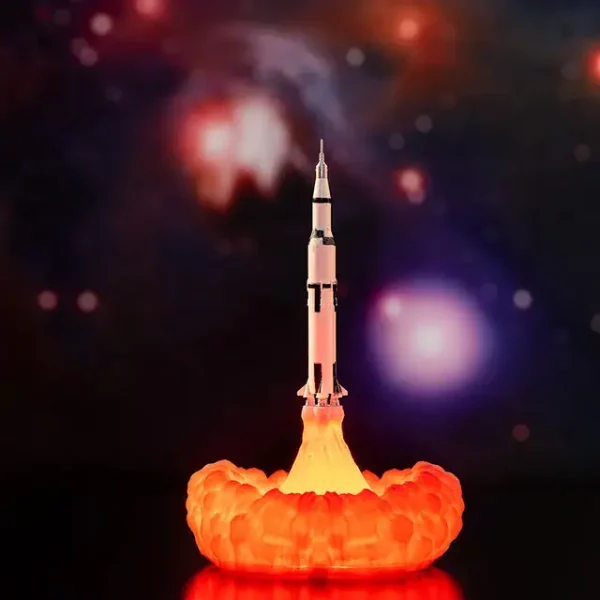 Raket under lansering med explosion av orange rök, som illustrerar ett vetenskapligt experiment eller en miniatyrmodell av raket i en utbildande eller dekorativ kontext.