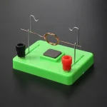 Demonstrationschip för elektrisk krets med spole, magneter och terminaler för vetenskapliga experiment.