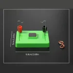 Demonstrationschip för elektrisk krets med trådar, magneter och grön plastbas, används för utbildande vetenskapliga experiment.