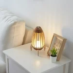 Bordslampa i trä och japanskt papper, som mjukt lyser upp ett hörn av rummet med en varm och naturlig atmosfär.
