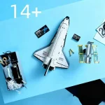 Minimodell av rymdskepp med vetenskapliga tillbehör, inklusive batterier, monteringsdelar och dekorativa element för astronomientusiaster.