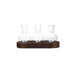 Tre transparenta glasflaskor placerade på en träbas, perfekta för vetenskaplig eller laboratoriedekoration.