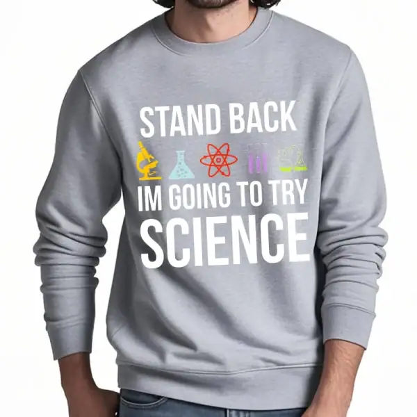 Grå sweatshirt med humoristiskt budskap "Håll dig tillbaka, jag ska försöka med vetenskap" och färgglada labbikoner, perfekt för vetenskaps- och skämtentusiaster.