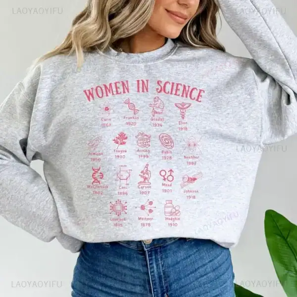 Grå t-shirt med illustrationer och namn på kända kvinnliga vetenskapsmän, som framhäver deras bidrag till vetenskapen.