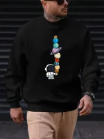 Svart sweatshirt med mönster av staplade färgglada planeter och en liten astronaut, idealisk för vetenskaps- och astronomientusiaster. Bekväm och trendig, perfekt för en avslappnad look.