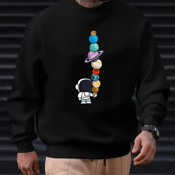 Svart sweatshirt med mönster av staplade färgglada planeter och en liten astronaut, idealisk för vetenskaps- och astronomientusiaster. Bekväm och trendig, perfekt för en avslappnad look.