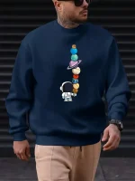 Blå hoodie med mönster av färgglada planeter och en liten astronaut, perfekt för vetenskaps- och astronomientusiaster.