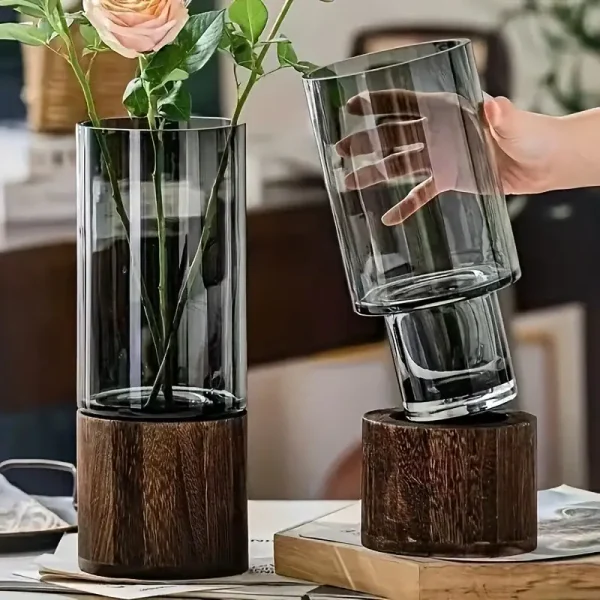 Transparent glasvas med träbas, idealisk för inredning eller som ett elegant vetenskapligt objekt. Perfekt för att framhäva blommor eller dekorativa element.