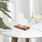 Transparent glasvas med bas av naturligt trä, modern dekoration för inredning, idealisk för att sätta blommor eller som elegant dekorativt objekt.