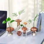 Svampliknande glasvaser med gröna växter och blommor, modern och originell kontorsdekoration.
