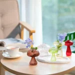 Svampliknande glasvaser med färgglada blommor på ett träbord, vetenskaplig och modern dekoration.