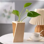 Modern trävas med grön växt, naturlig och elegant inredning.