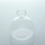 Transparent glasflaska som används i vetenskapligt laboratorium, med en smal hals och rund form, idealisk för experiment och dekoration.