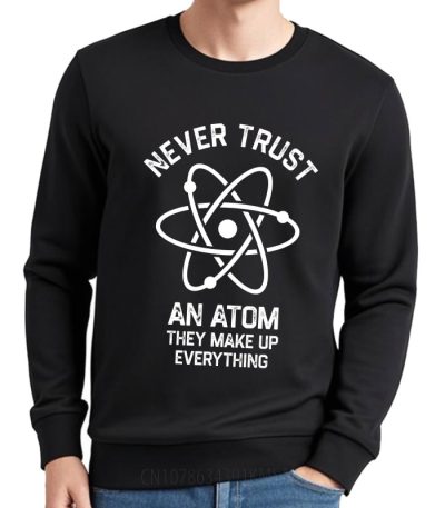 Svart sweatshirt med atomiskt mönster och text "Lita aldrig på en atom, de hittar på allt" för vetenskapsentusiaster.