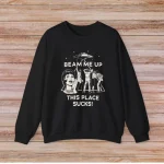 Svart t-shirt med humoristisk illustration och text "Beam me up, this place sucks!" för vetenskaps- och humorentusiaster.