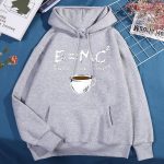 Ekvationen E=MC² med en illustrerad kaffekopp, symbol för energi och vetenskap, på en grå hoodie.