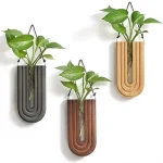 Hängande vasar i trä och metall med gröna växter, modern och naturlig dekoration för inredning, elegant design, perfekta för att försköna ditt hem eller arbetsutrymme.